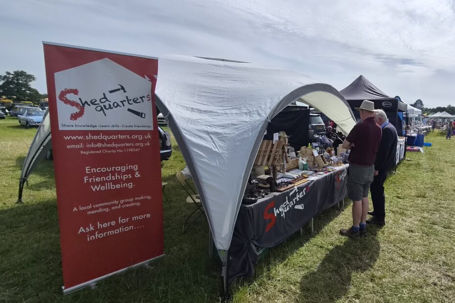 Shedquarters stand at Stoke Row Steam Rally with display banner, gazebo and member made items.